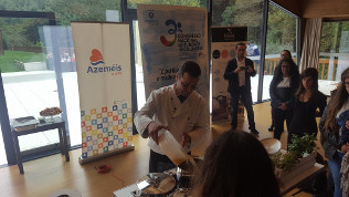 Alunos observam uma demonstração culinária.