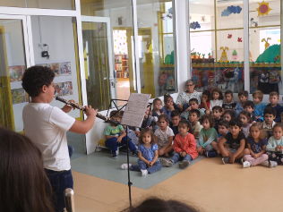 Alunos ouvem com atenção uma peça.